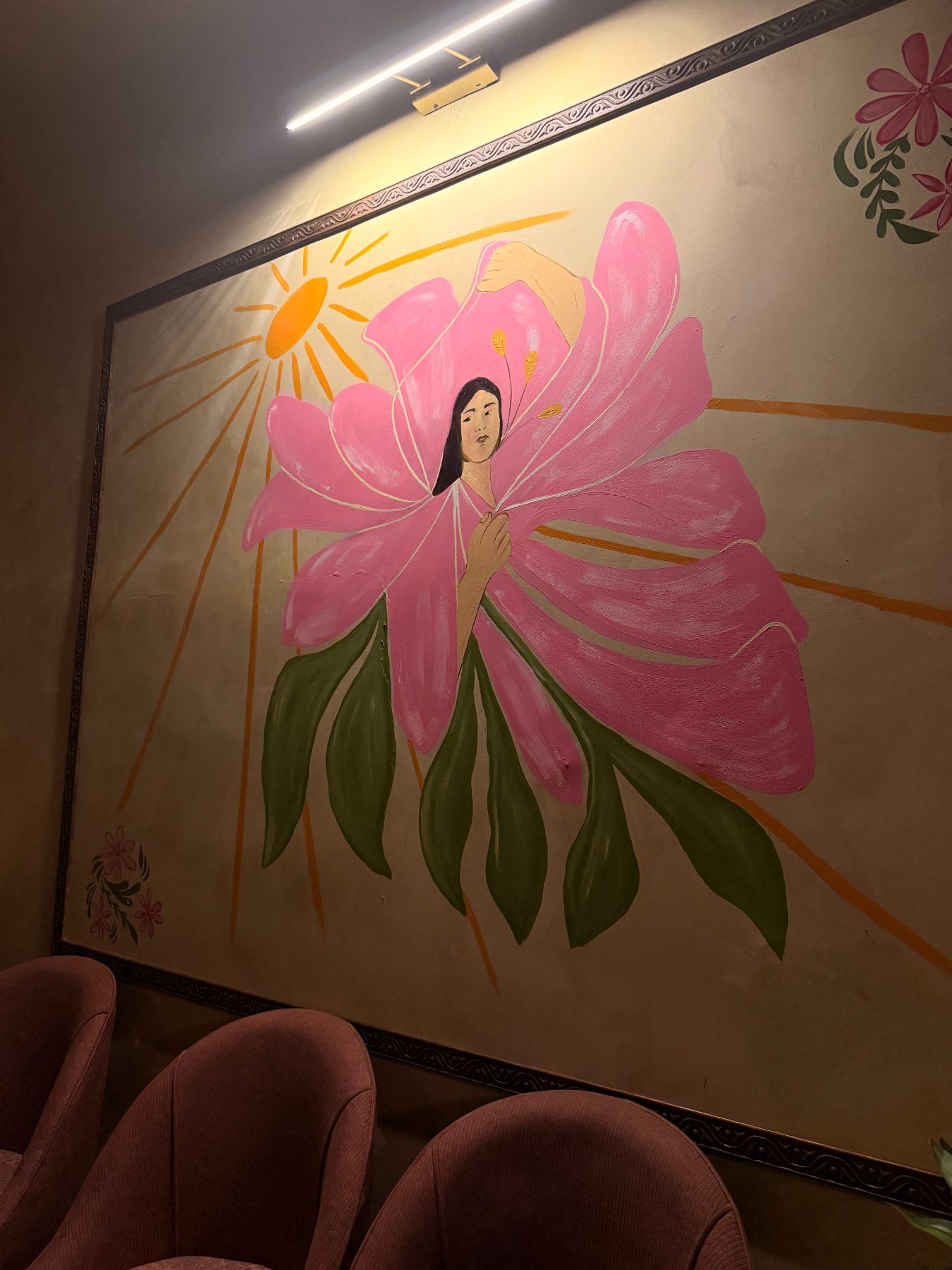 Lucia’s painted mural of a woman in a pink blossom